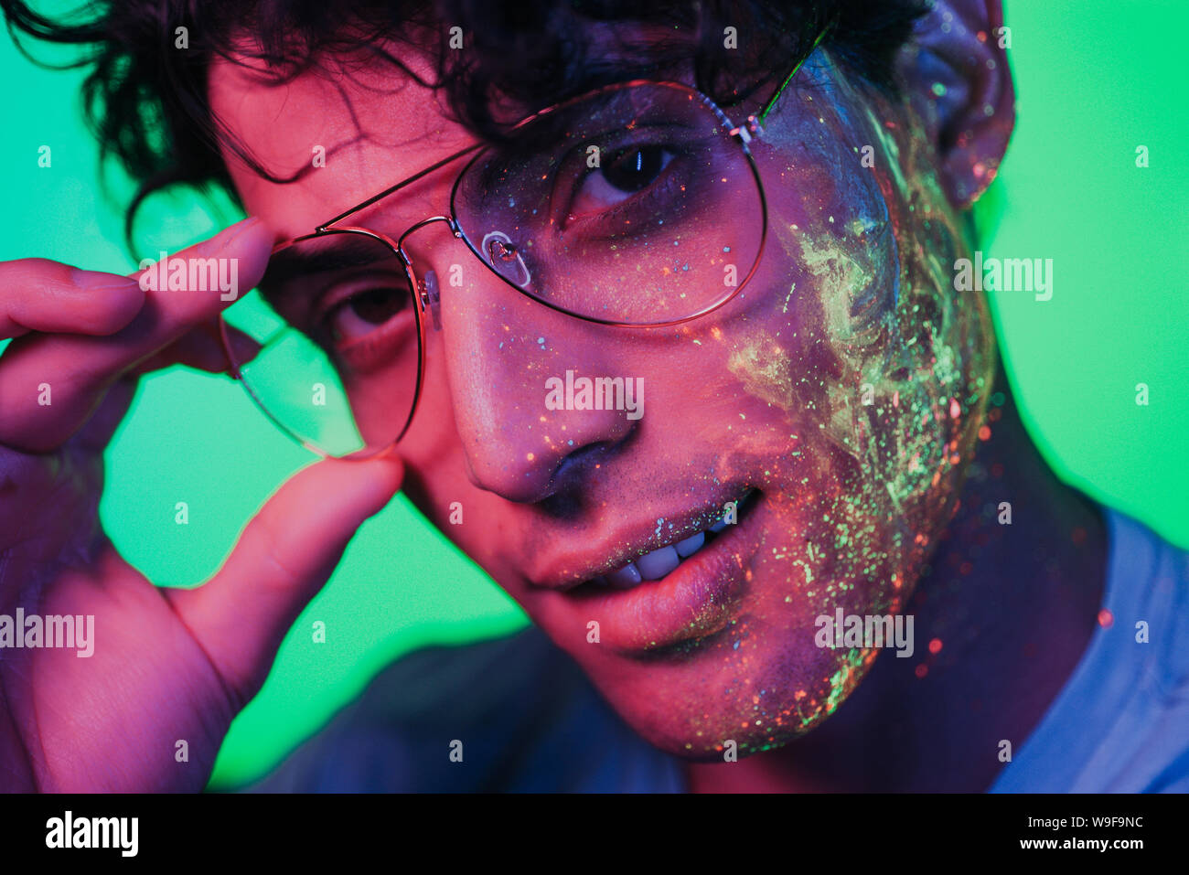 Handsome boy dancing at the rave party with fluorescent paintings on ...