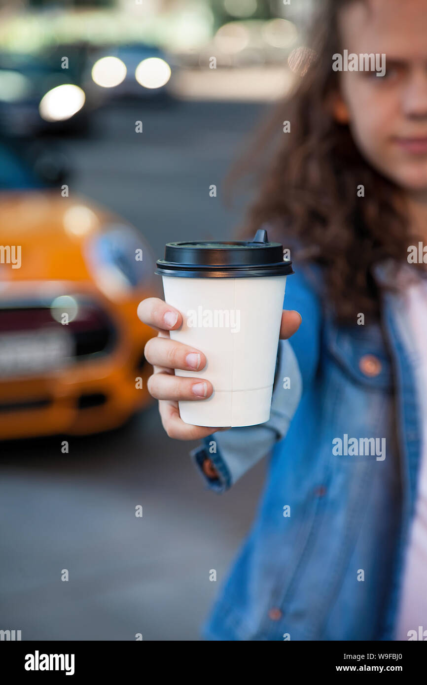 hand holding a drink with coffee in a paper Cup on the background of a big city Stock Photo