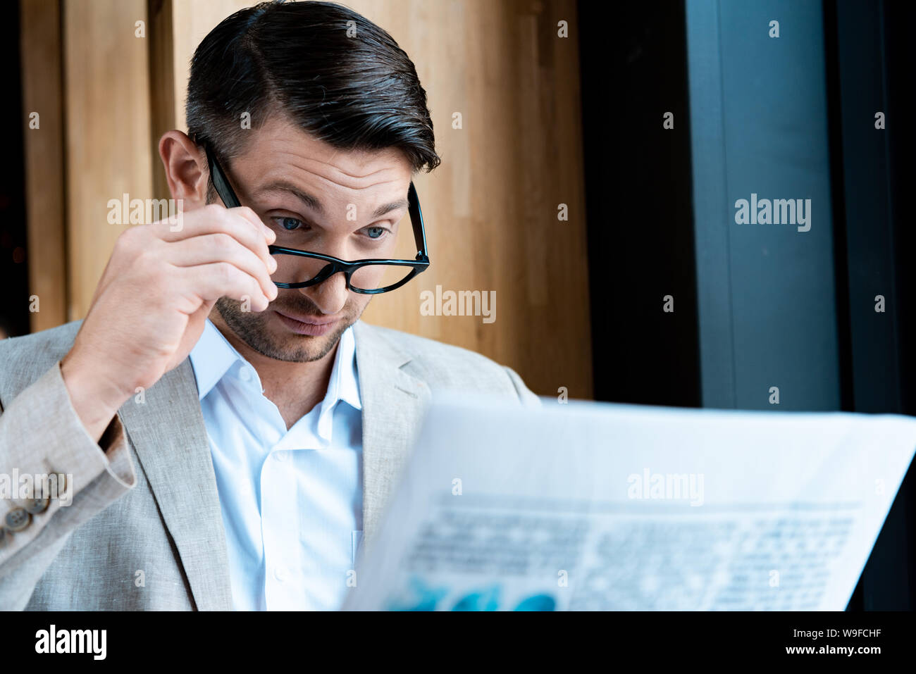 surprised businessman in glasses reading newspaper in cafe Stock Photo ...