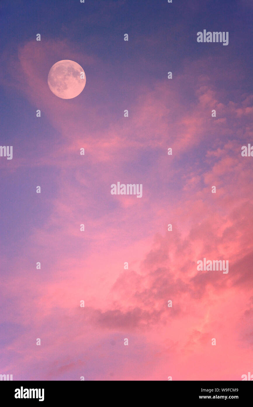 Full moon in sky with pink clouds Stock Photo Alamy
