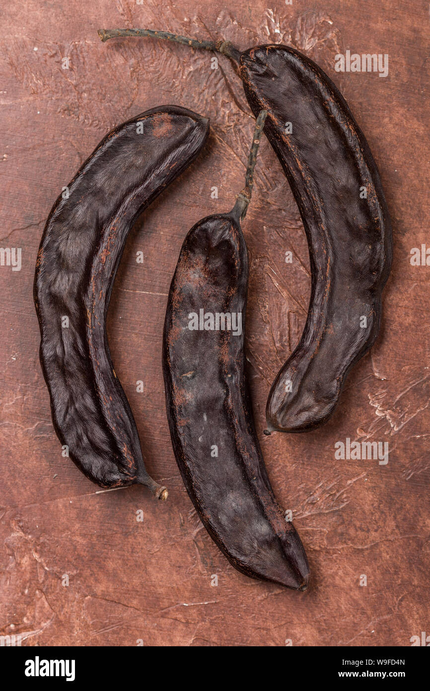 Carob. Healthy organic sweet pods with seeds. Healthy eating. Selective focus, top view Stock