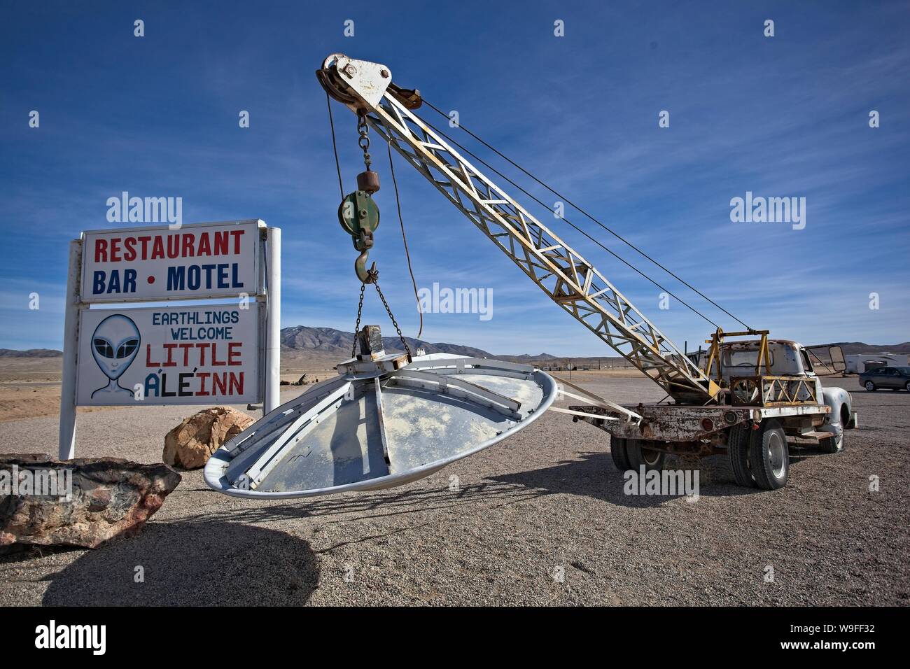 An antique tow truck holding a model of the flying saucer outside of the little A'Le'inn in Rachel Nevada Stock Photo