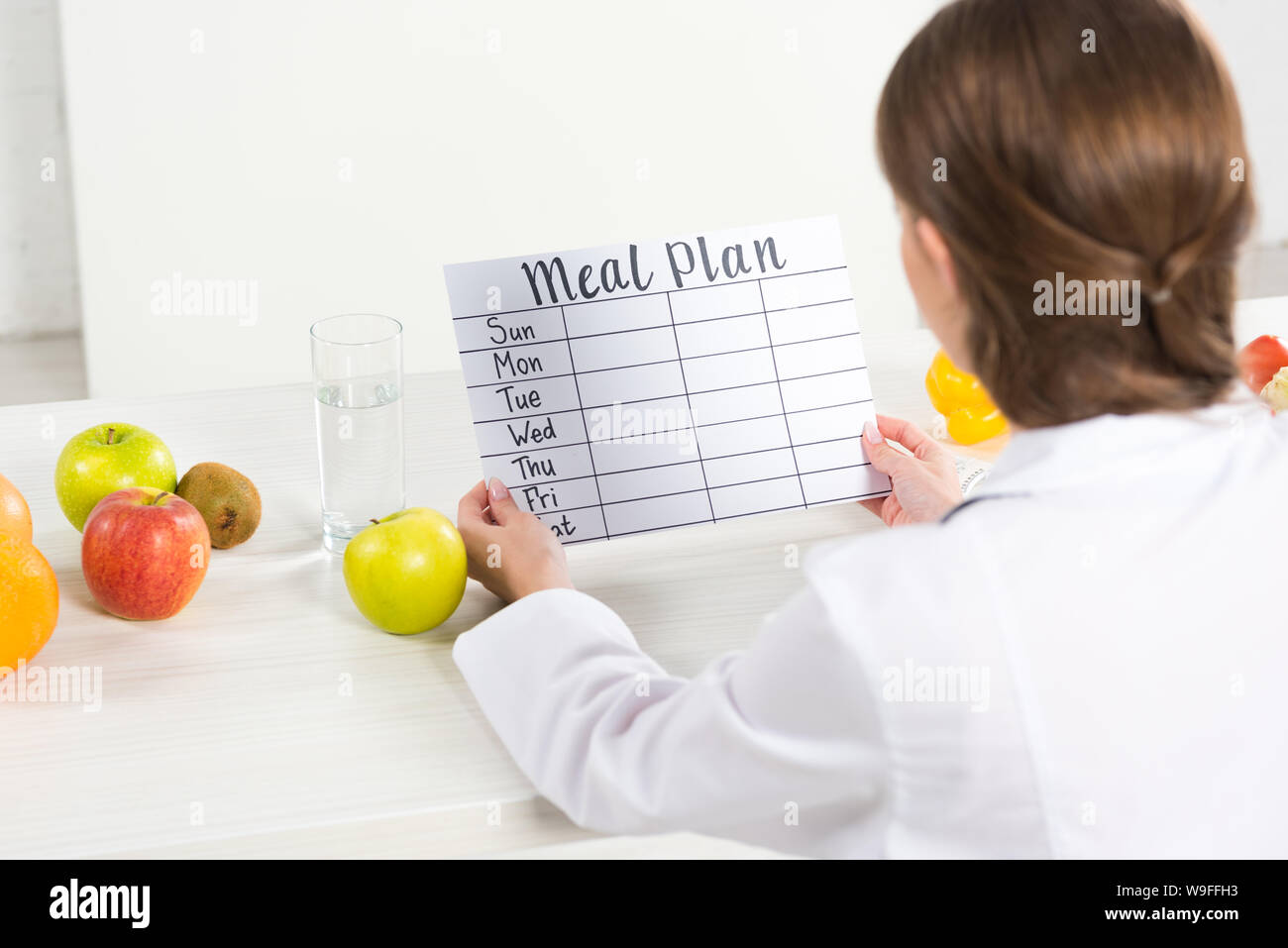 back view of dietitian holding meal plan at workplace Stock Photo