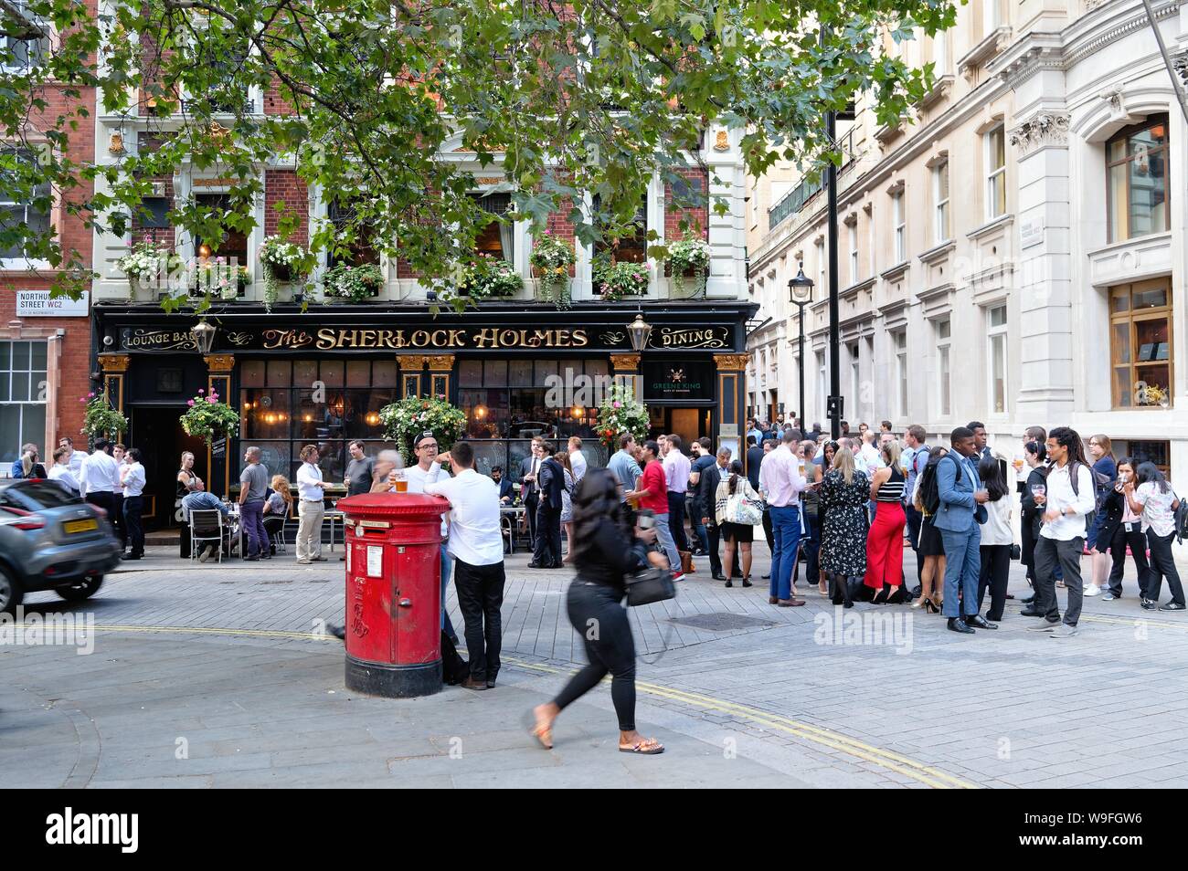 Crowds enjoying a summers evening drink outside The Sherlock Holmes  public house on Northumberland Street, Central London England UK Stock Photo