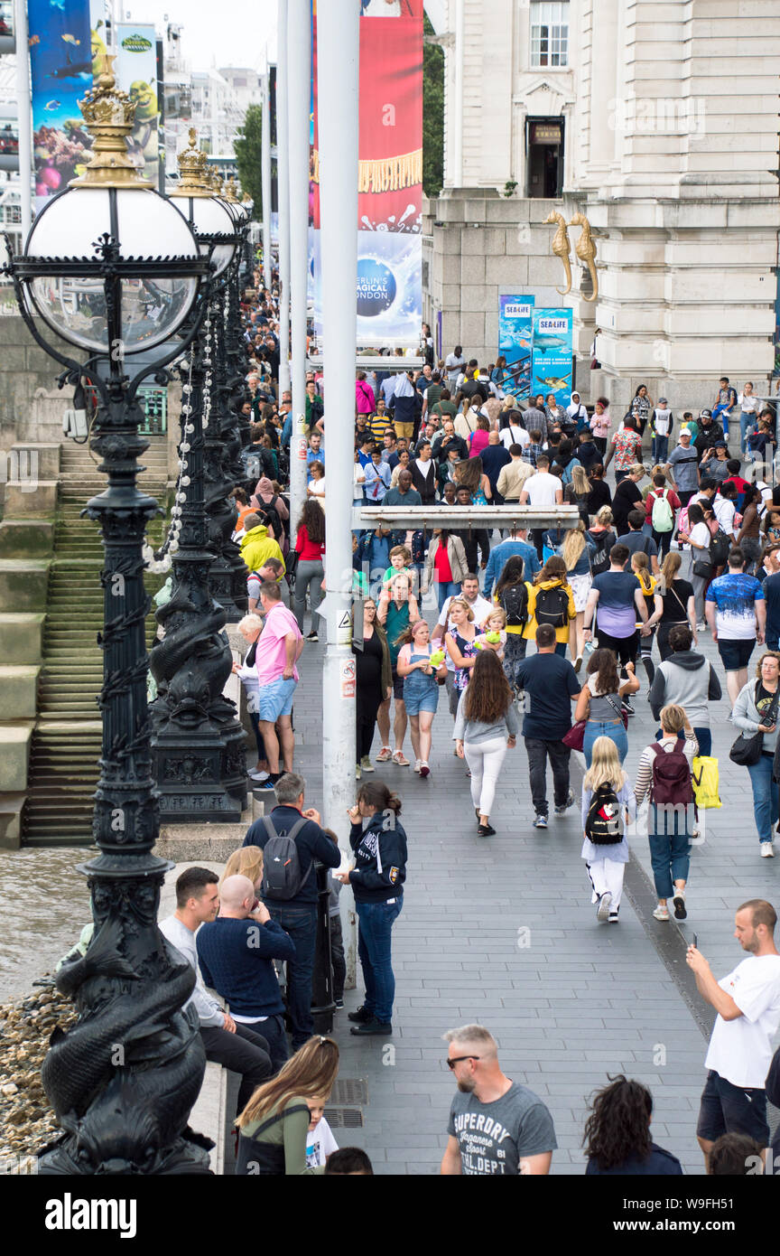 Tourists and Visitors filled South bank of river thames near London eye Stock Photo