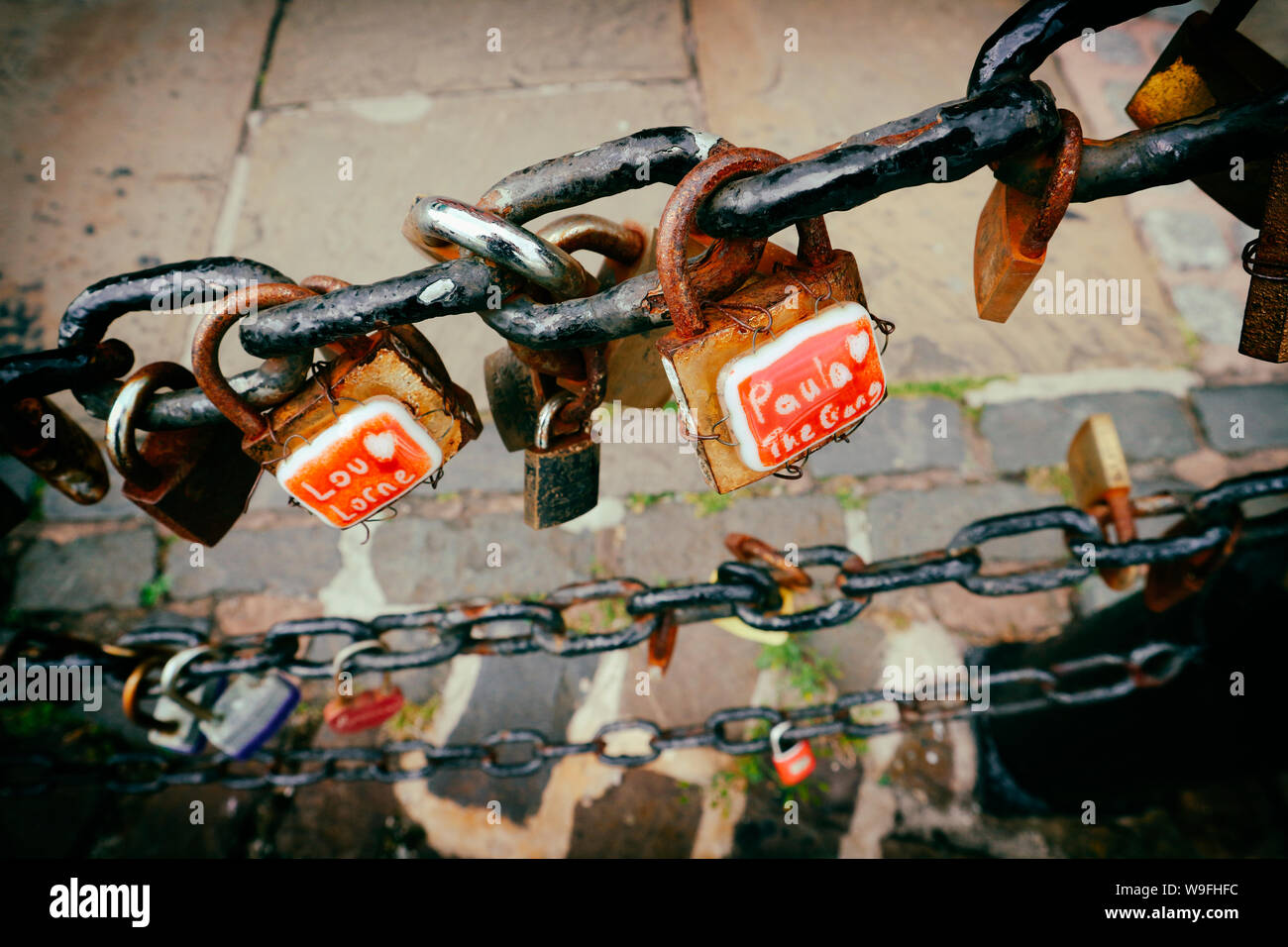Love padlocks hanged on iron chain fence at Liverpool harbour on Royal