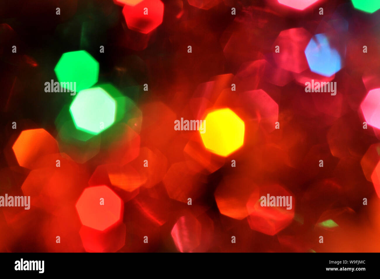 Christmas background.Glowing and festive colored light circles created from in camera and lens bokeh. Christmas fairy lights defocused giving a blurred. Stock Photo