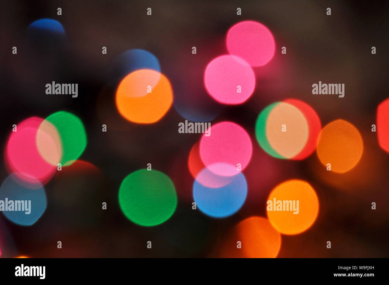 Christmas background.Glowing and festive colored light circles created from in camera and lens bokeh. Christmas fairy lights defocused giving a blurred Stock Photo