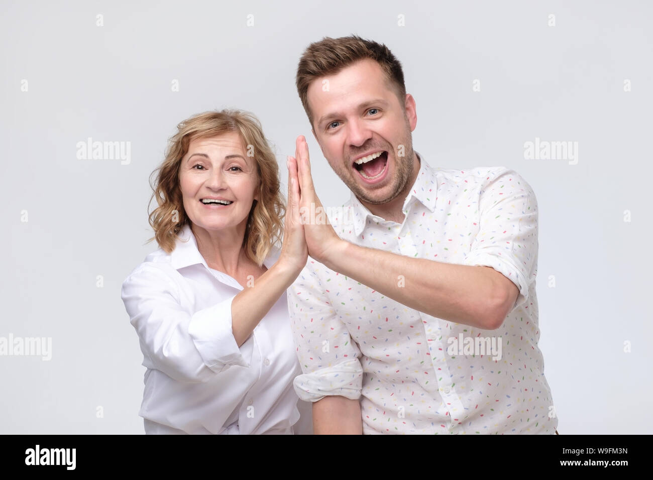 woman and man friends give five looking at camera as friendship ...
