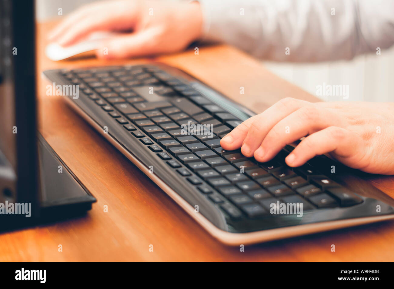 Man using computer, buy things online, searching informations or work at home. Soft focus image color graded Stock Photo