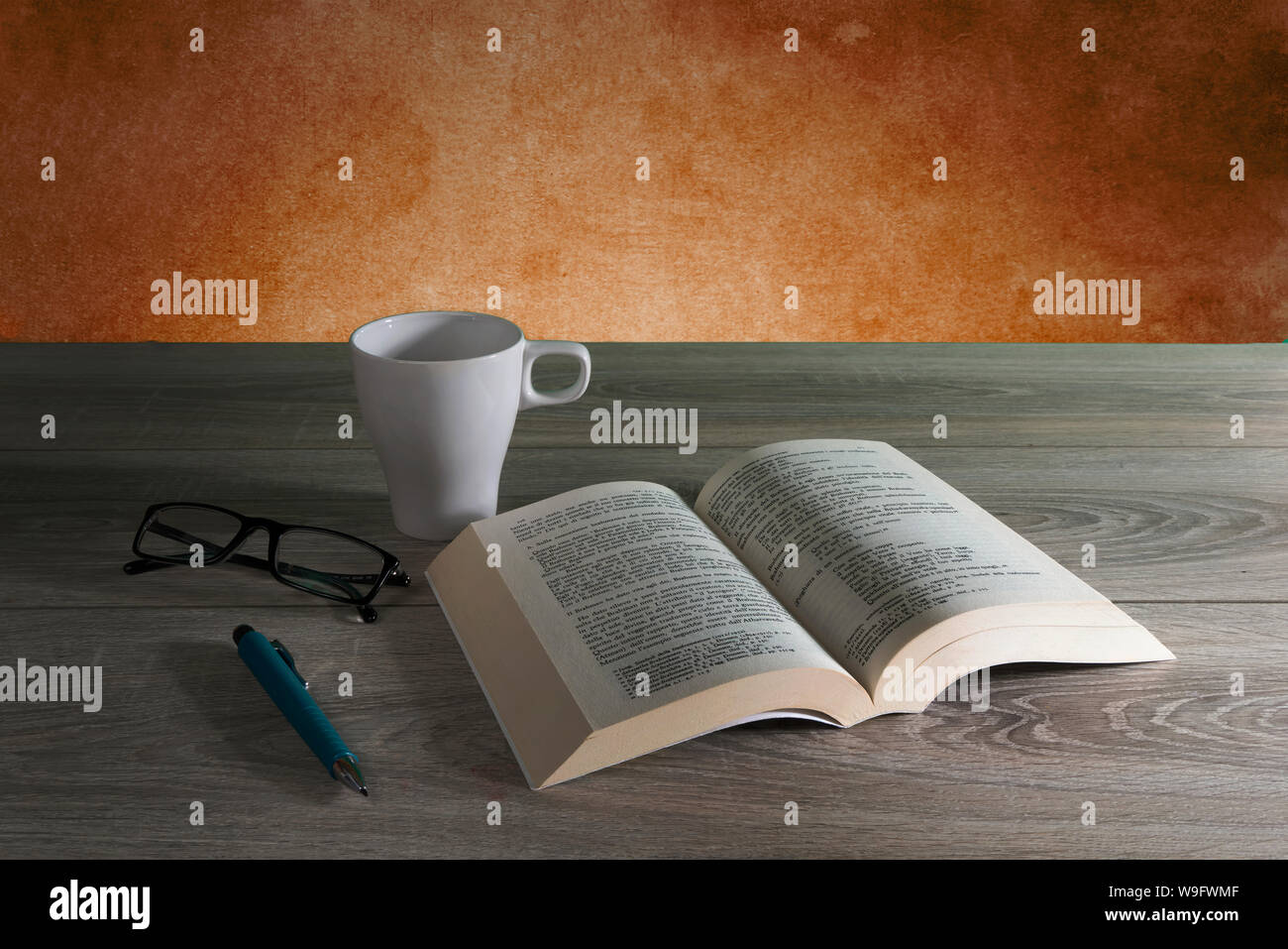a book on a wooden table with a cup of coffee Stock Photo