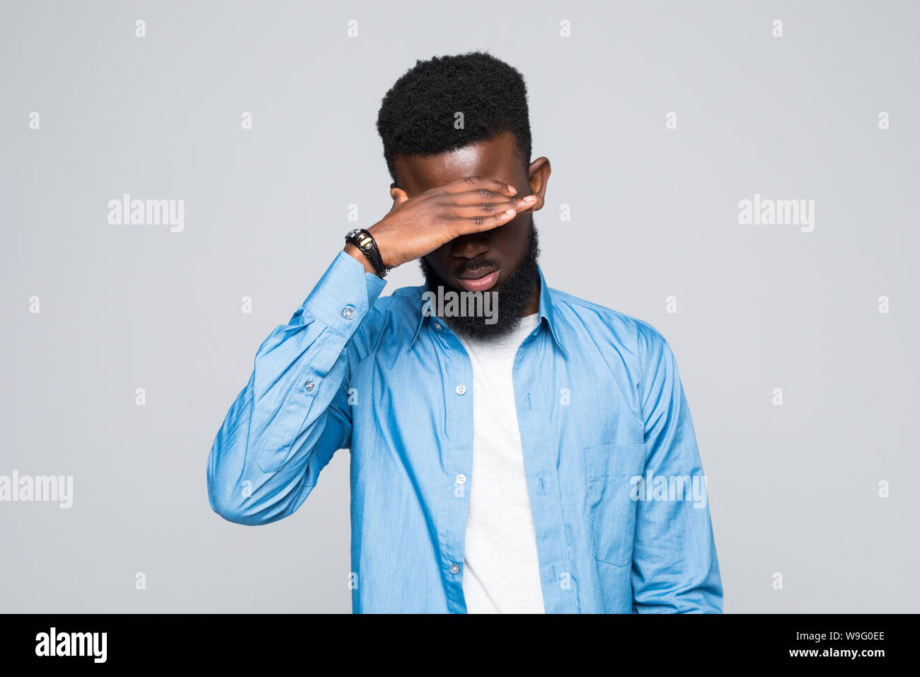Closeup portrait of young male, shy man closing covering eyes with hands can't see, hiding, isolated on white background. Stock Photo