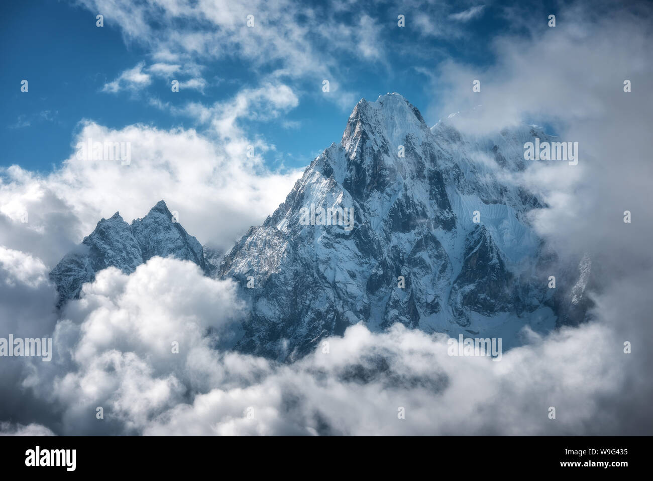 Manaslu mountain with snowy peak in clouds in sunny bright day Stock Photo
