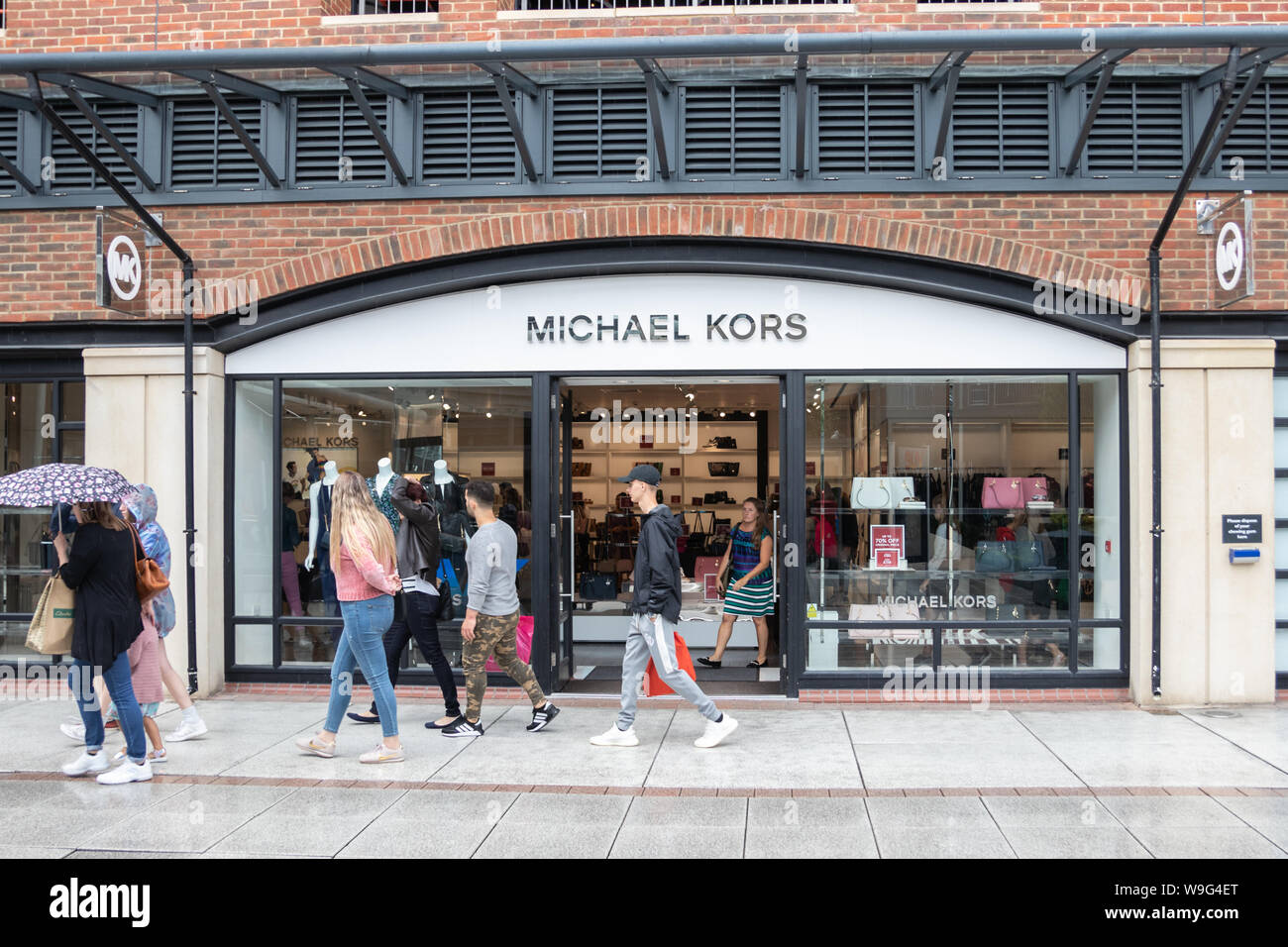 Shoppers walk past a shop window of a Michael Kors store in the rain Stock  Photo - Alamy