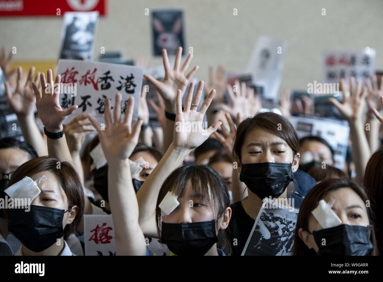 Sha Tin, Hong Kong, China. 13th Aug, 2019. Hospital staff and protesters participate in a peaceful sit in demonstration in the lobby of the Prince of Wales Hospital in Sha Tin, Hong Kong to express their opposition to violent tactics employed by Hong Kong Police. Pro-democracy demonstrators in Hong Kong have added eye patches to their unofficial uniform of black T-shirts, hard hats and gas masks, after a protester was reportedly hit by a bean bag round and blinded. Credit: Adryel Talamantes/ZUMA Wire/Alamy Live News Stock Photo