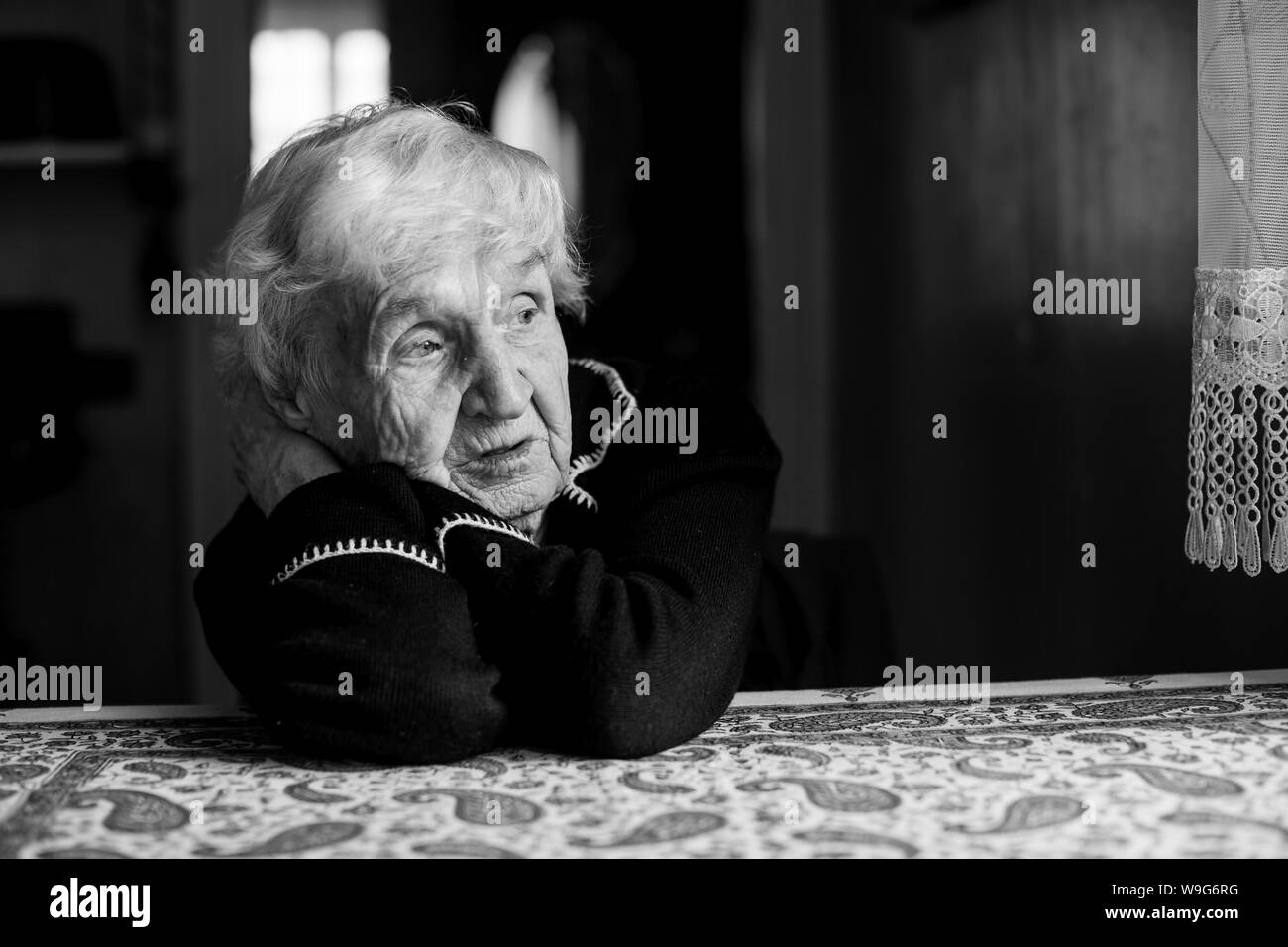 Lonely sad old woman. Black and white photo. Stock Photo