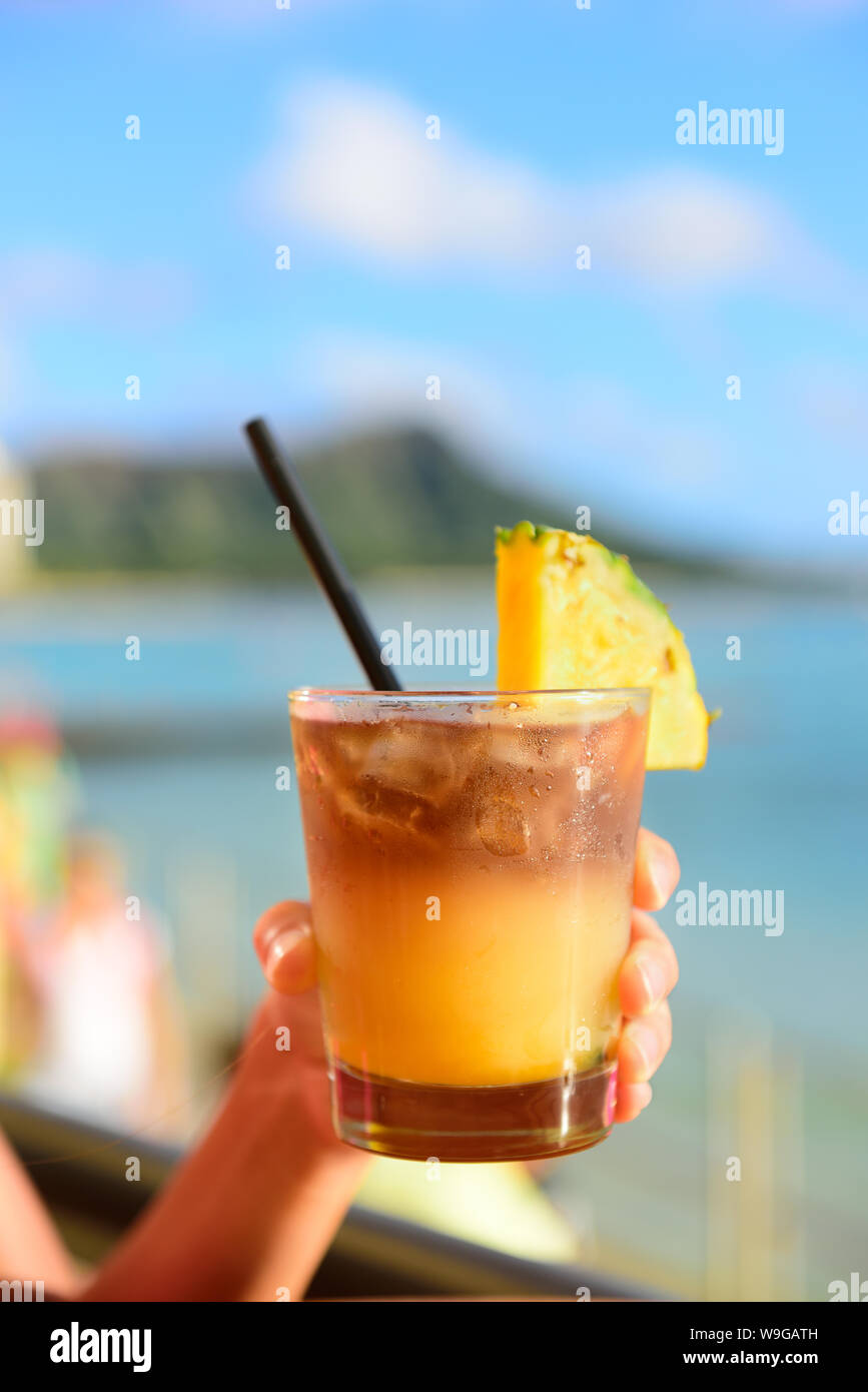 Mai Tai hawaiian drink on beach bar. Close up of alcoholic drink. Friends toasting having fun on Waikiki beach, Honolulu city, Oahu, Hawaii USA. Stock Photo