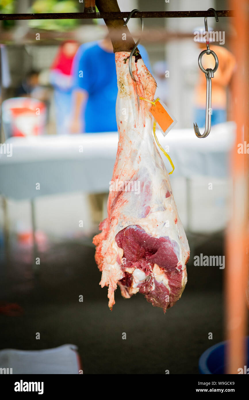 Raw meat  hanging from the metal hook from animal slaughtering performed on one to third day of Hari Raya Aidil Adha in Malaysia. Stock Photo