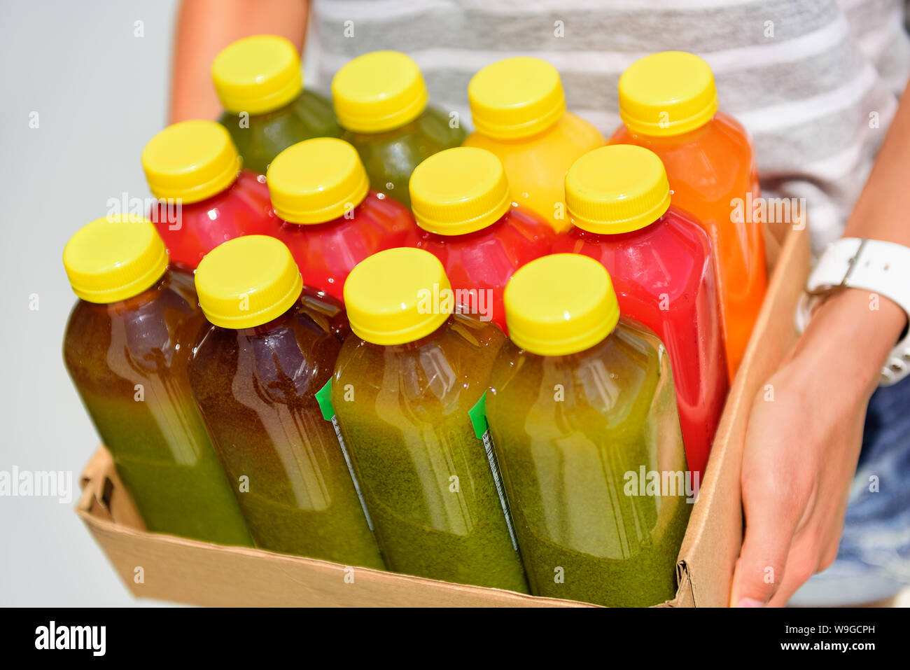 Organic cold-pressed raw vegetable juice plastic bottles. Latest food trend consisting of juicing at high pressure fresh fruits and vegetables without heating to preserve nutrients and vitamins. Stock Photo