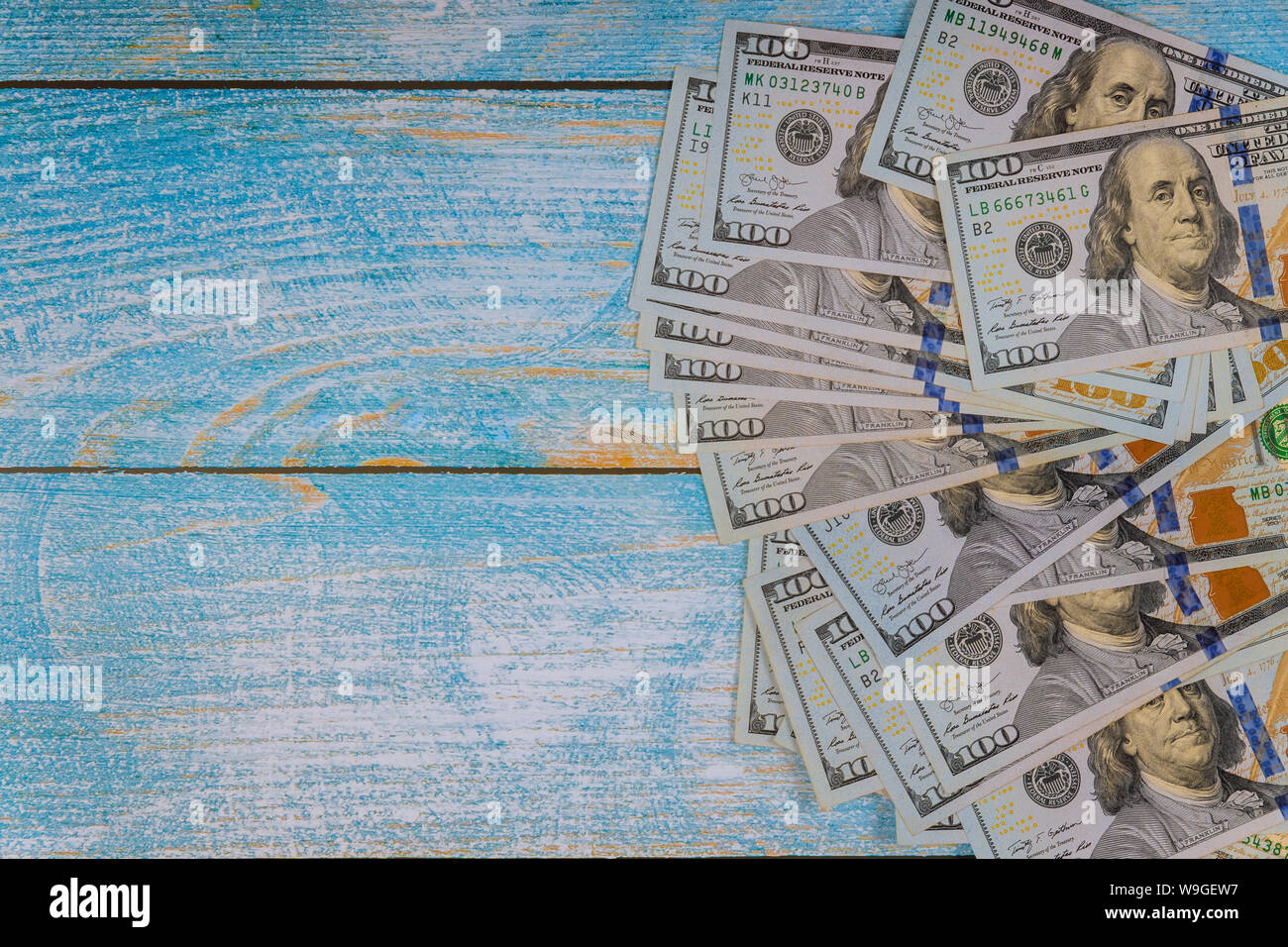 One hundred dollars on a blue background. One hundred dollar bills. Stock Photo