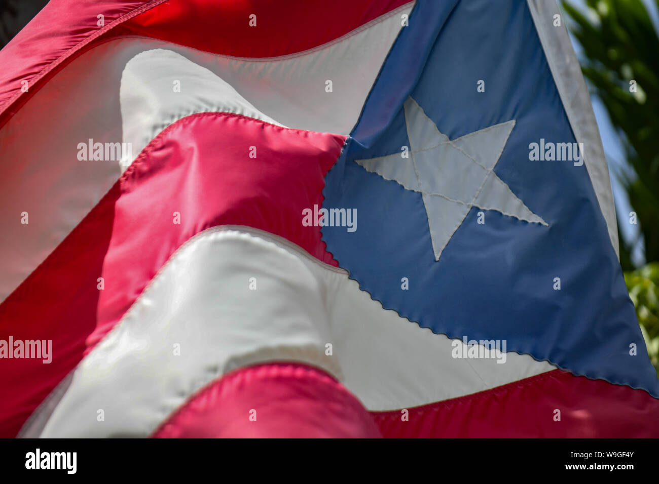 Puerto Rico a tattered Puerto Rican flag flies in old San Juan Puerto Rico -  a torn Puerto Rico flag flaps in the breeze Stock Photo