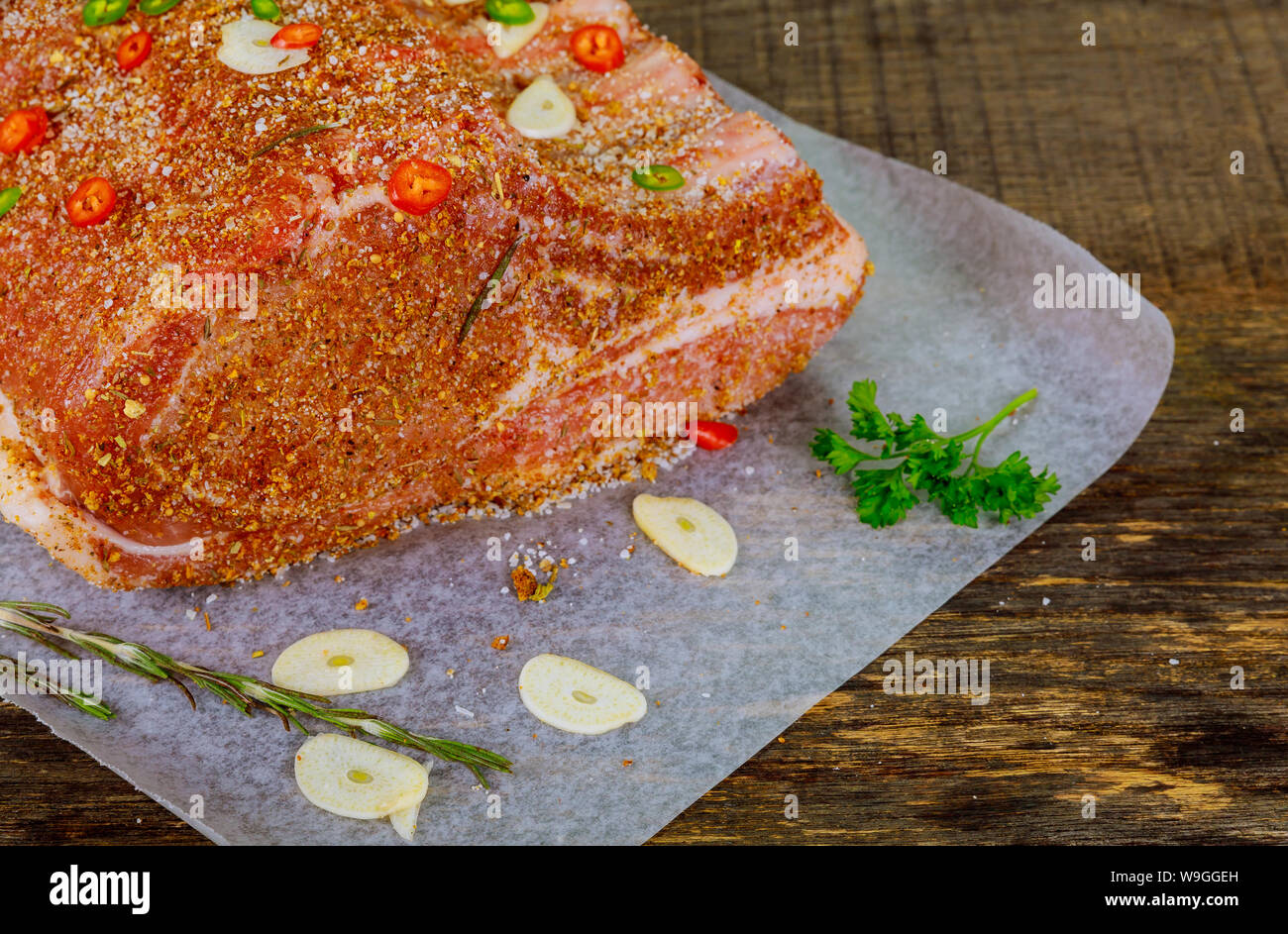 Raw pork loin on ribs with herbs and spice on parchment paper Stock