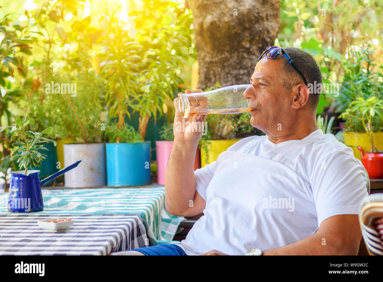 Man drinking beer. Side view of handsome middle eastern senior man