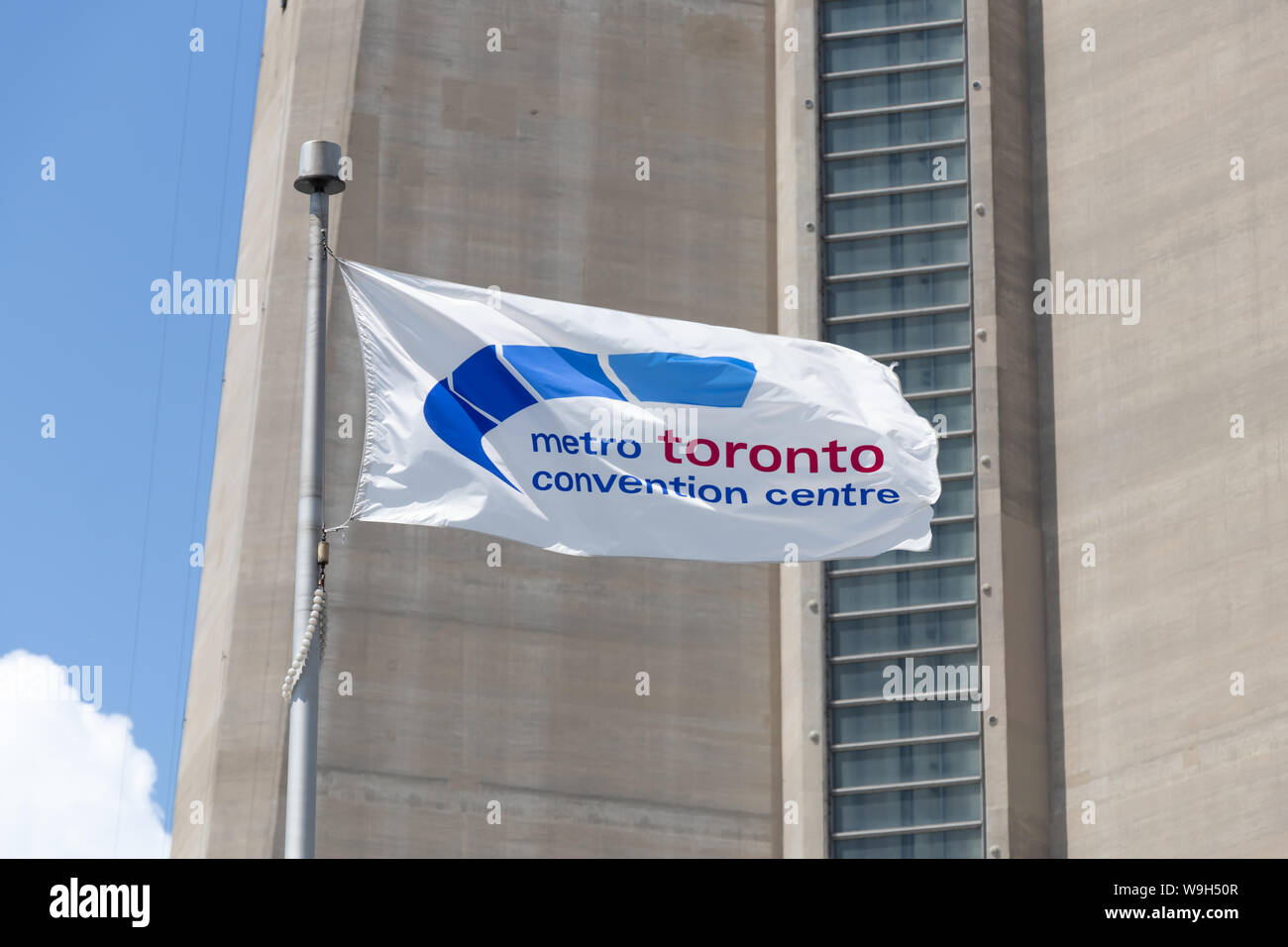 Metro Toronto Convention Centre flag waving with CN Tower behind. Stock Photo