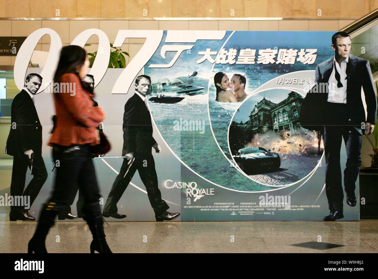 A Chinese woman walks by the advertising poster of new James Bond (007