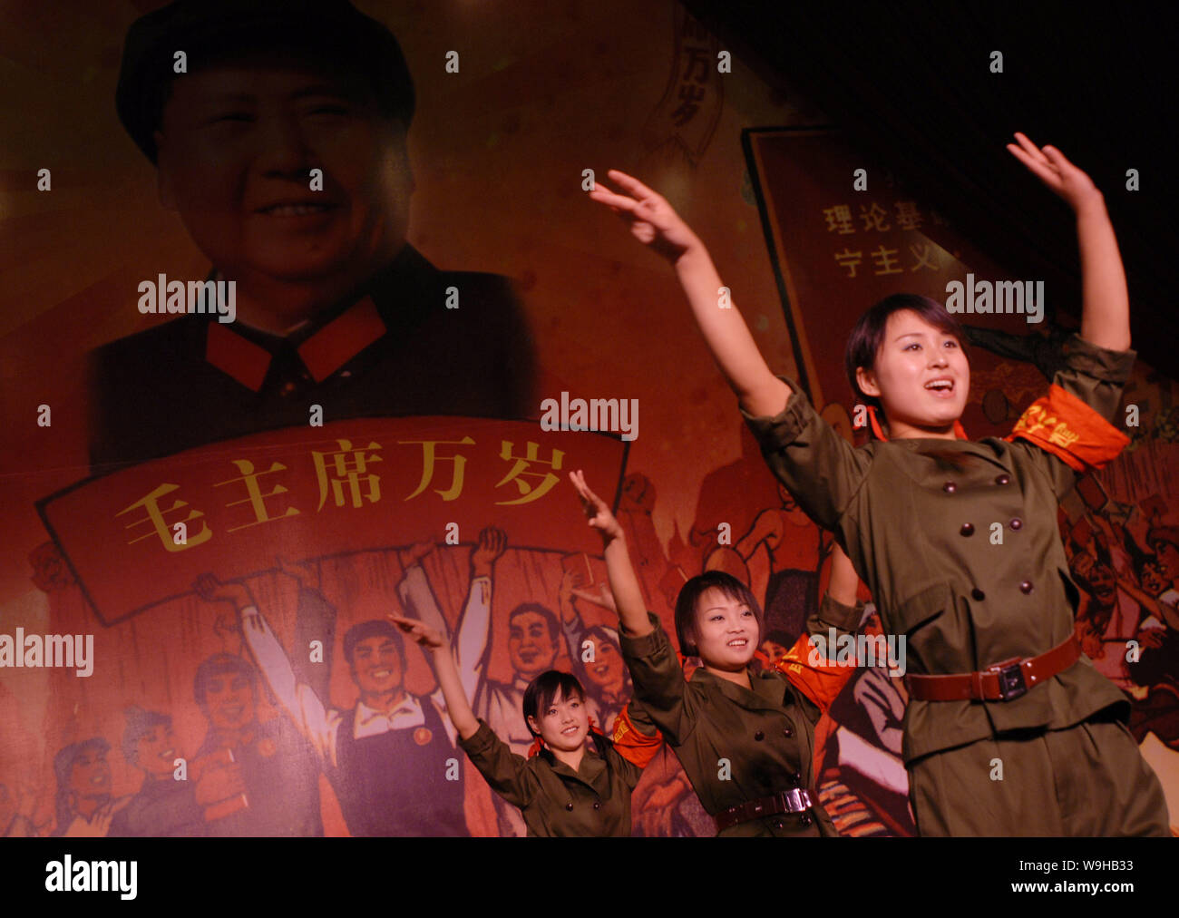 Chinese waiters dressed like red guards during the Cultural Revolution period perform revolutionary songs and dances at a Cultural Revolution themed r Stock Photo