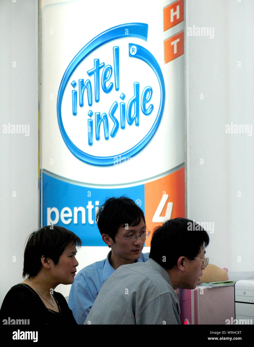 Chinese customers shop for desktop computers as an advertisement of Intel Pentium 4 is seen in the background at a digital product shopping mall in Ni Stock Photo