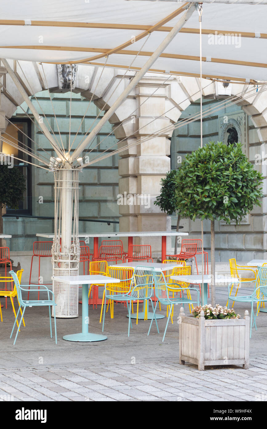Colourful chairs and tables under a canopy Stock Photo Alamy