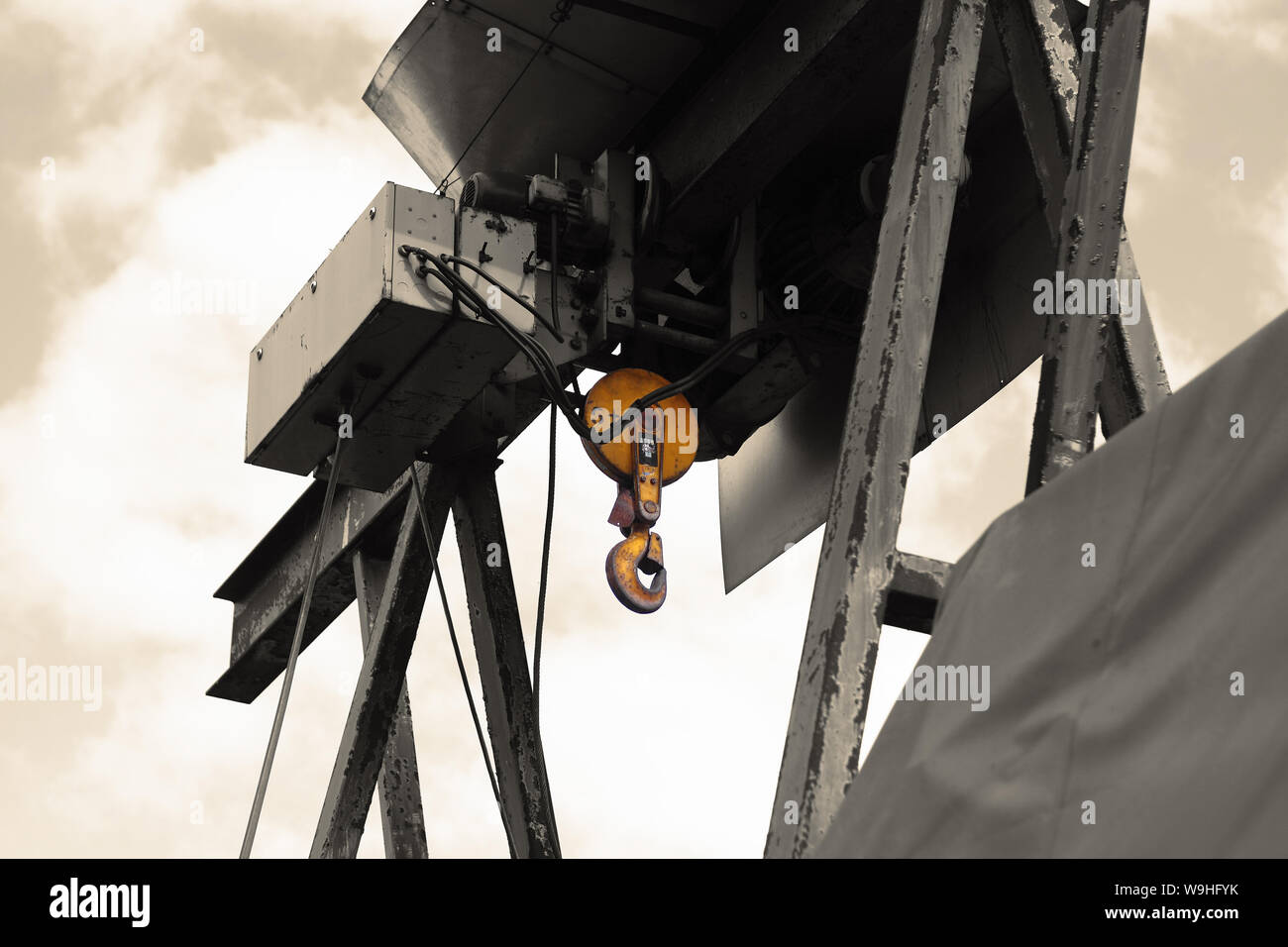 Old electric power crane hoist on a steel frame. Colour toned and