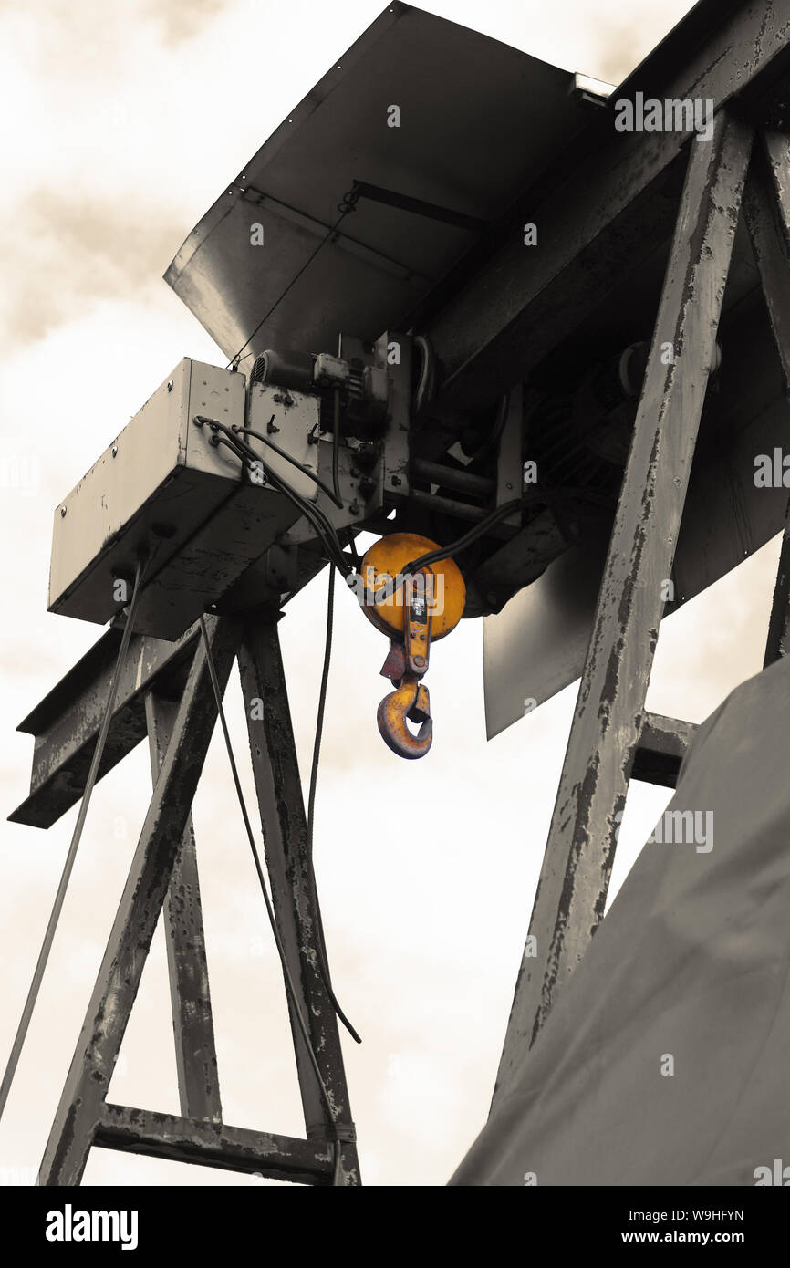 Old electric power crane hoist on a steel frame. Colour toned and
