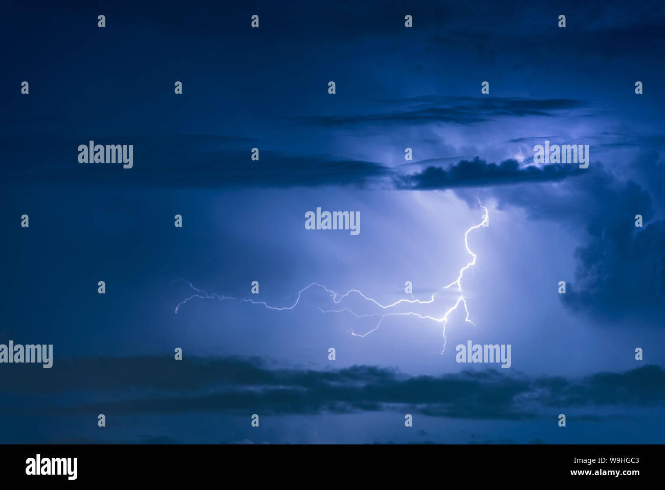 Thunder storm lightning strike on the dark cloudy sky background at ...