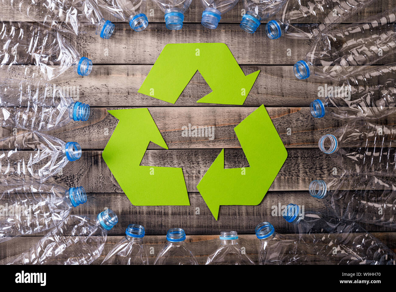 Frame of used plastic bottles with recycling symbol on wooden background. Recycle concept Stock Photo