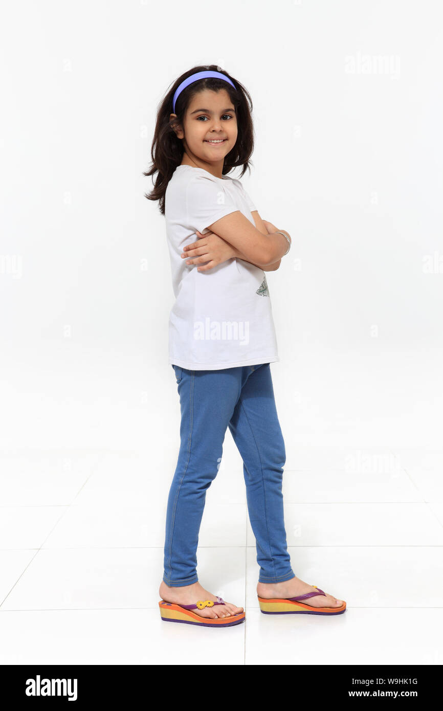 Girl standing with her arms crossed and smiling Stock Photo - Alamy