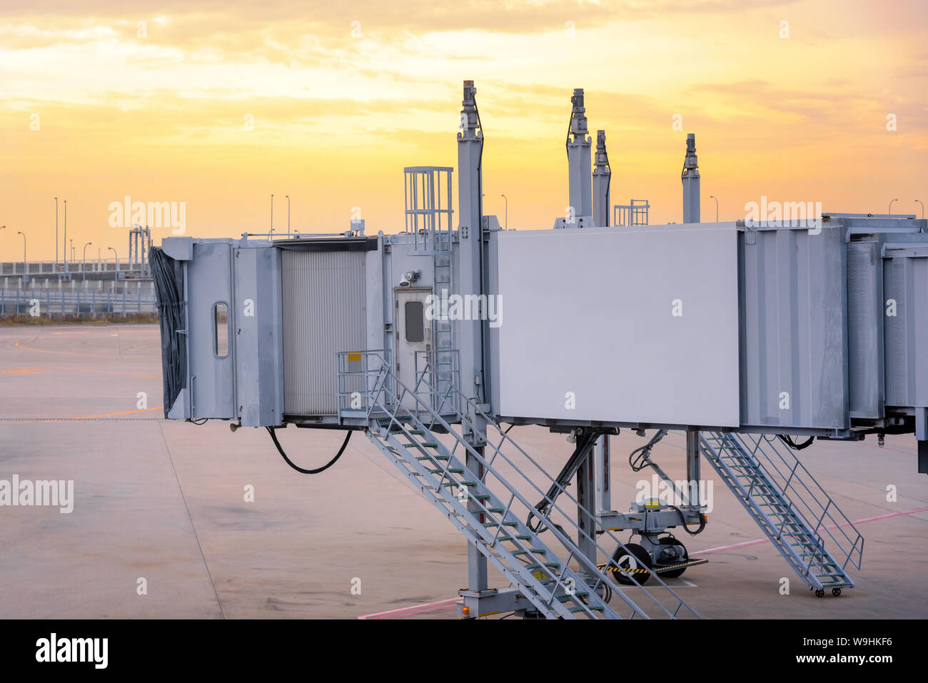 Passenger boarding bridge waiting for a plane to arrive at international airport terminal gate. Stock Photo