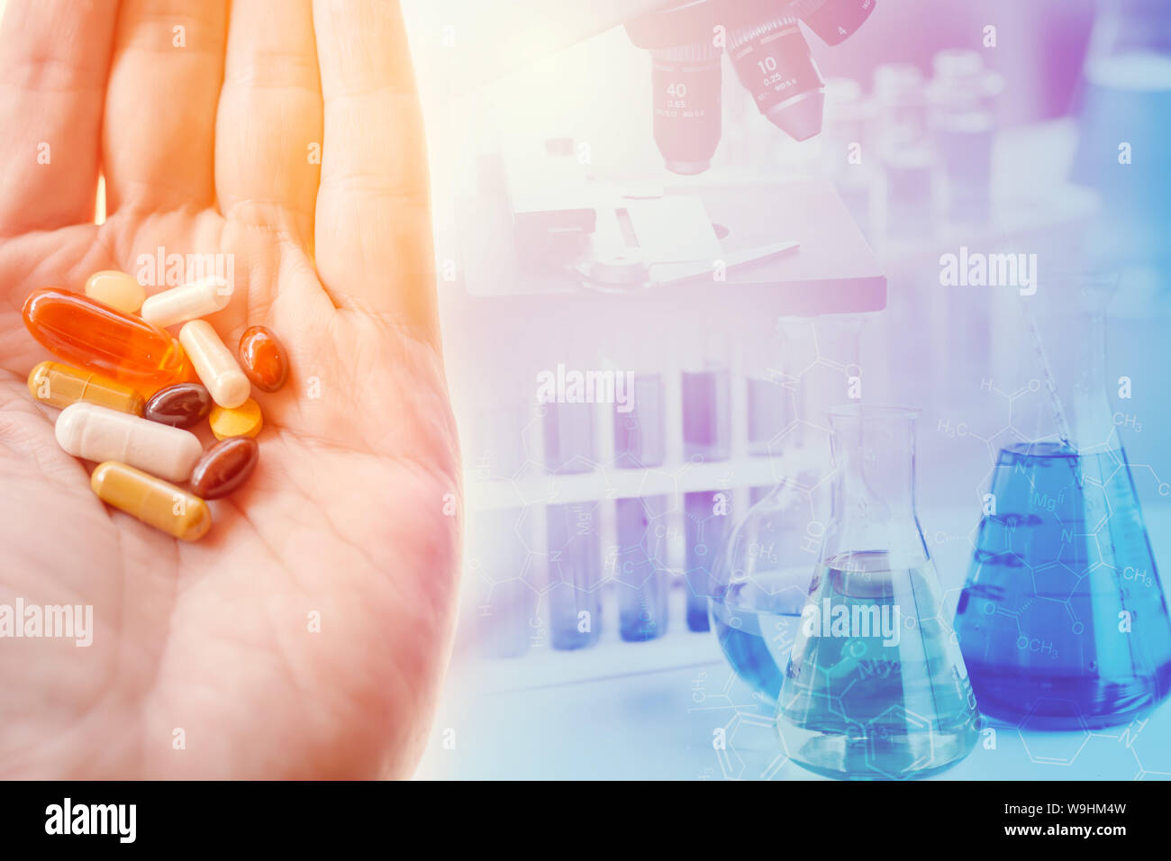 medical science concept. medicine pills in hand with chemical lab research and development in laboratory background Stock Photo