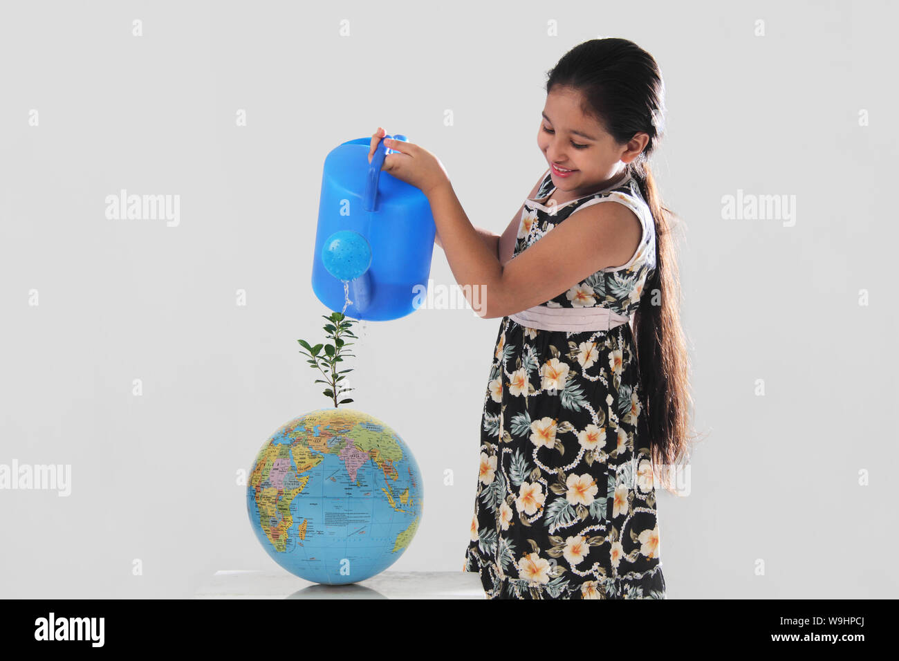 Girl watering a plant Stock Photo