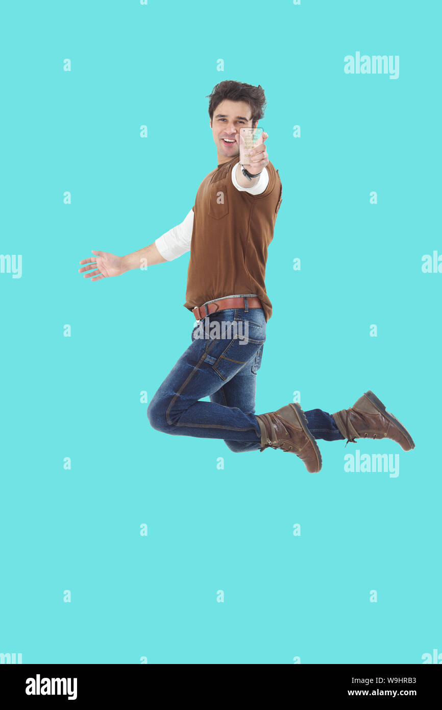 Young man showing transparent mobile phone and jumping Stock Photo