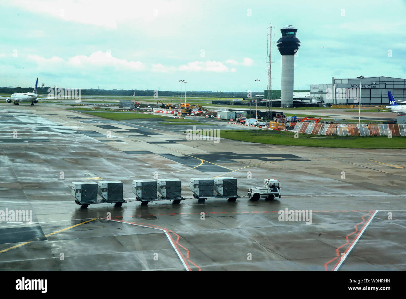 Baggage handlers on the runway at terminal one Manchester Airport Stock