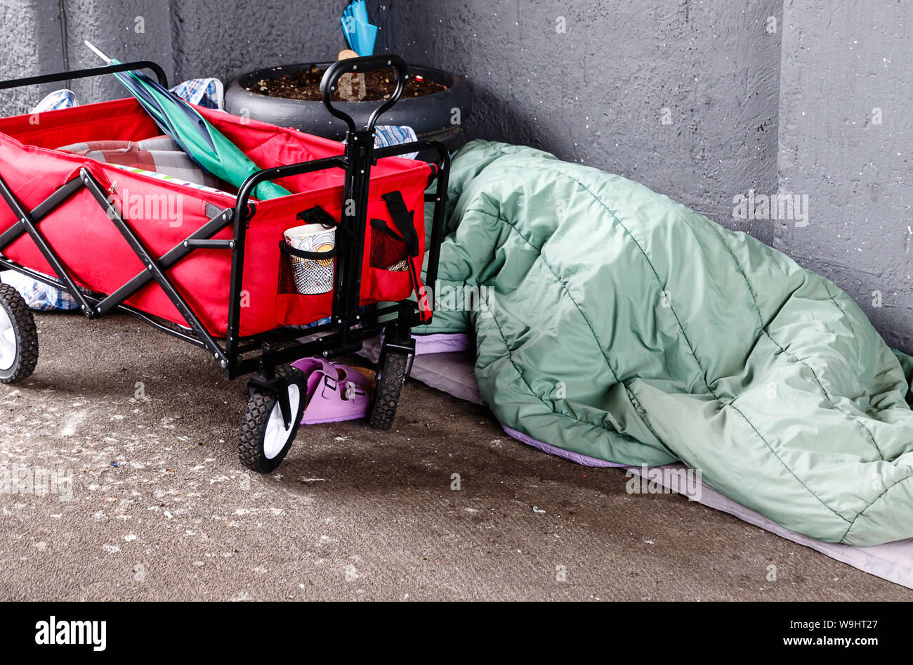 Homeless person sleeping on the street in the corner of a building in the Hafen City quarter of Hamburg, Germany Stock Photo