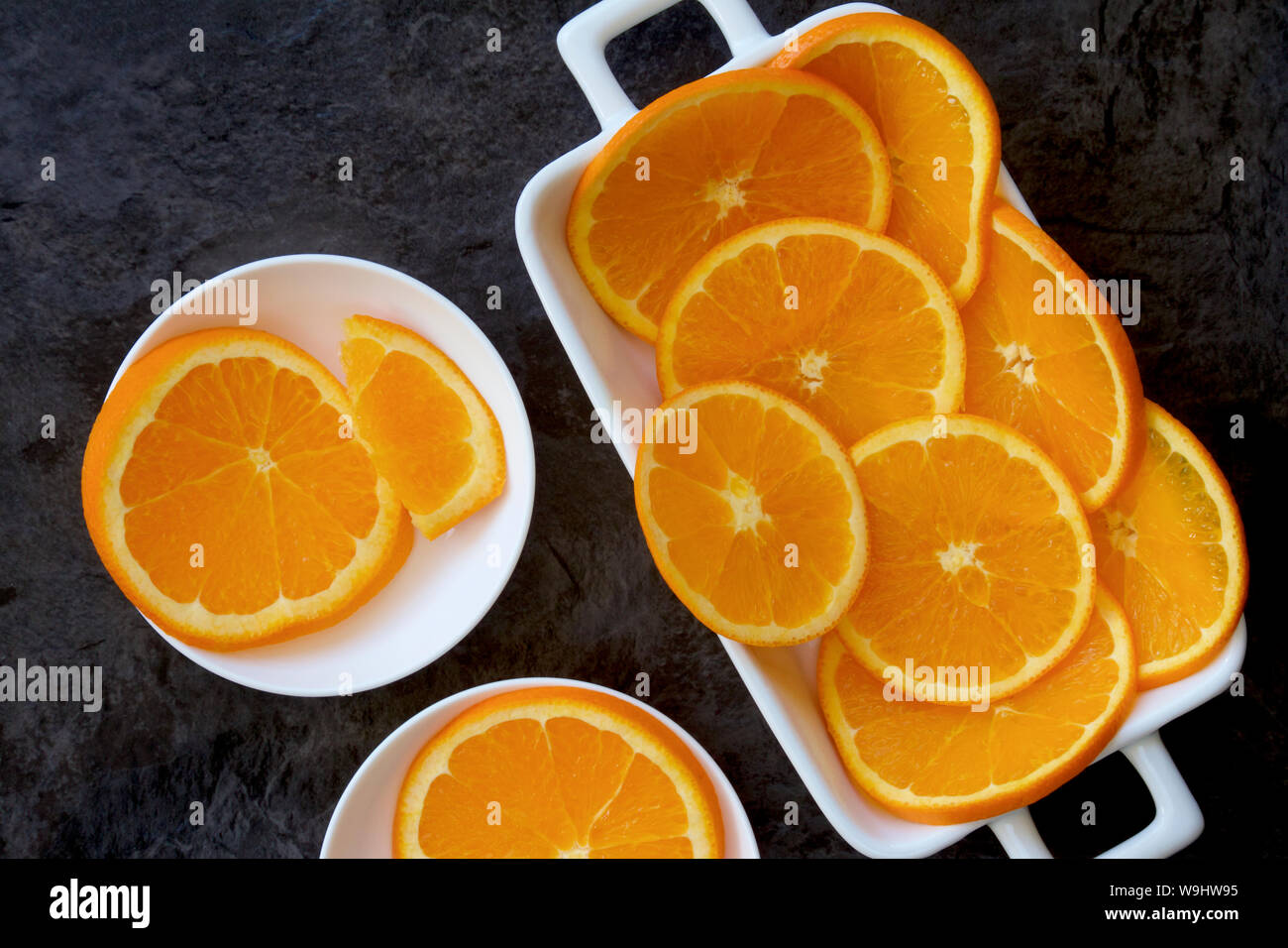 Slices of orange fruit on a white plate. Stock Photo