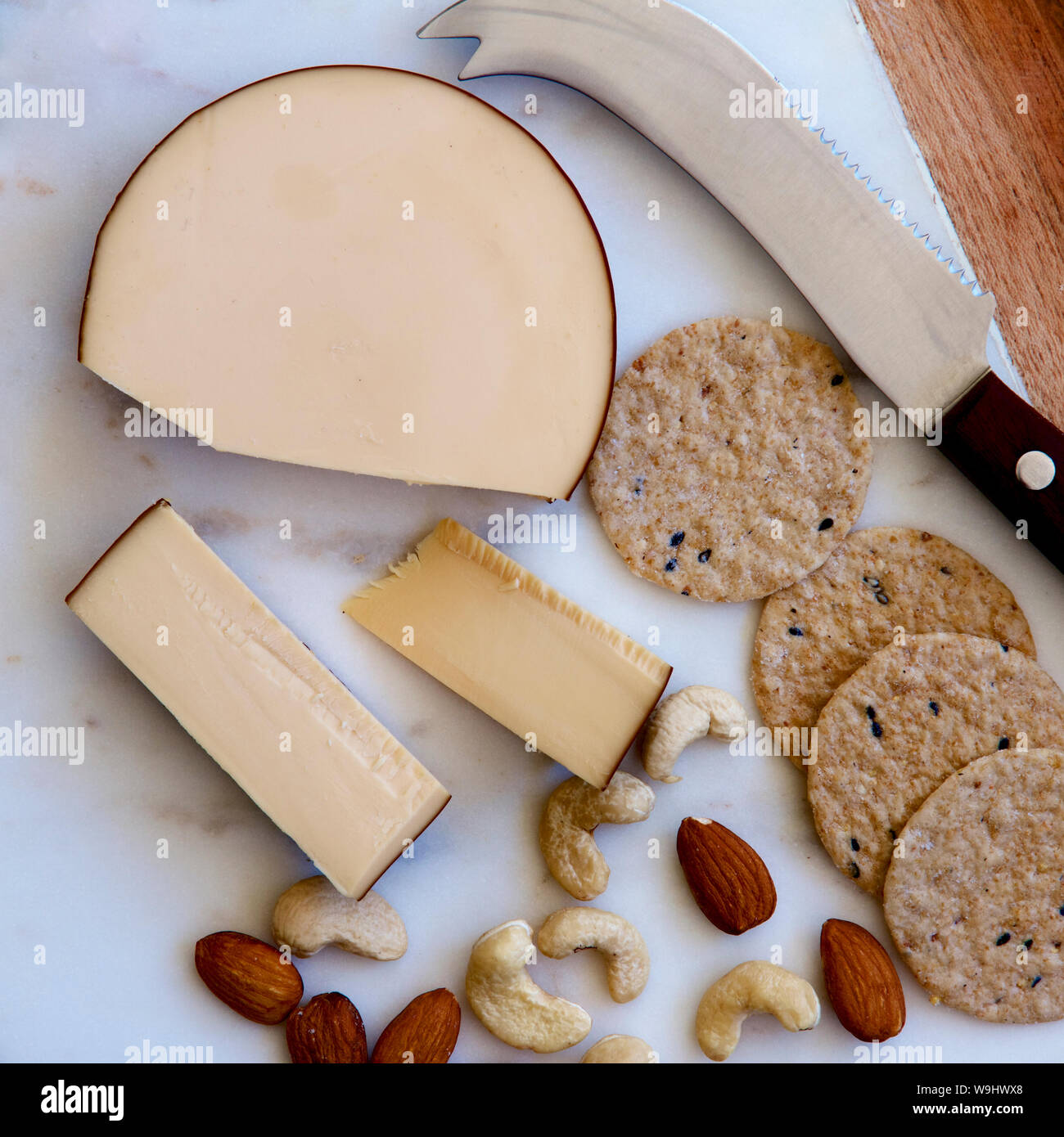 Biscuits and cheese with nuts on a board. Stock Photo
