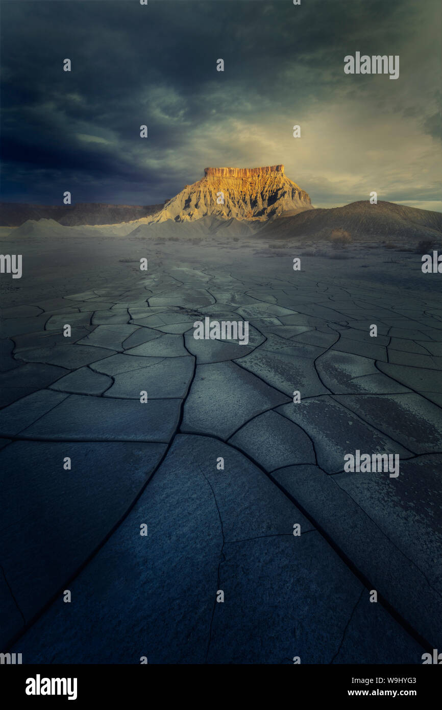 Dry land, mud cracks with epic mountain in the background Stock Photo