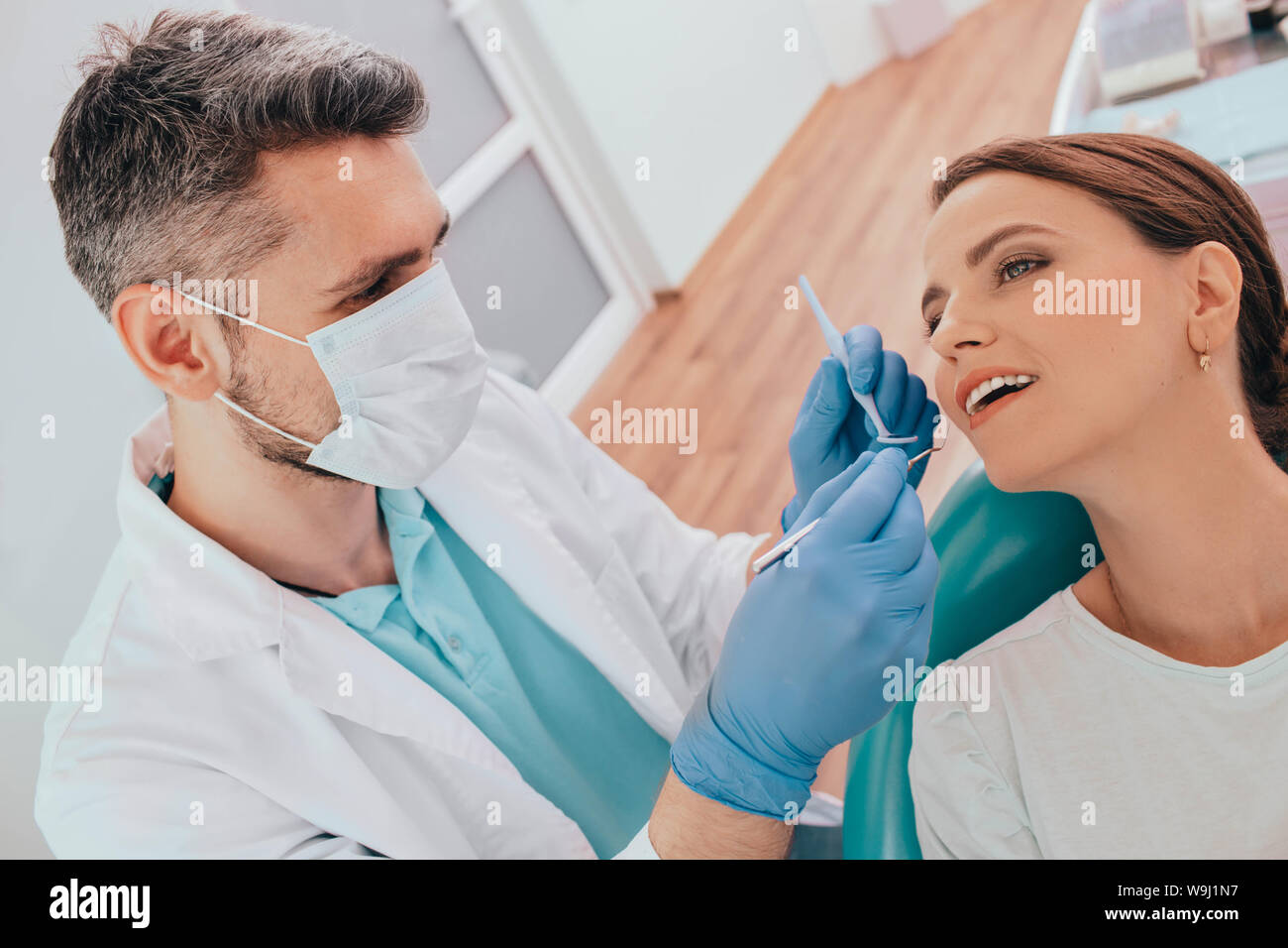 woman getting plaque removal with dental equipment by her dentists at clinic Stock Photo