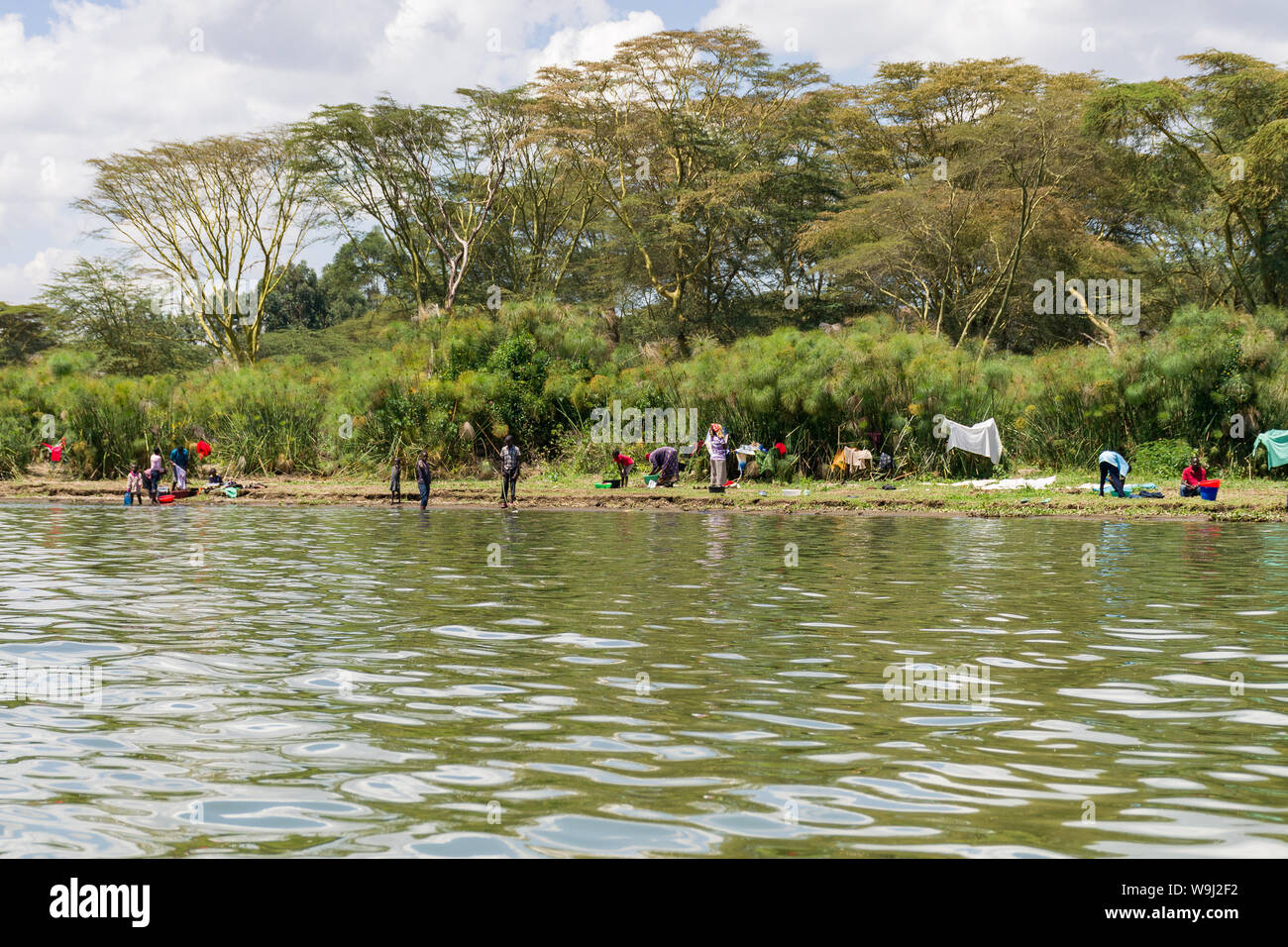Local Kenyans washing clothes at the shore of lake Naivasha, Kenya, East Africa Stock Photo