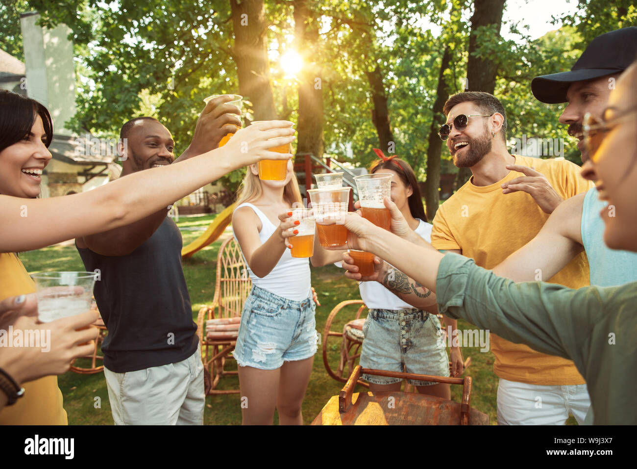 Group of happy friends having beer and barbecue party at sunny day ...
