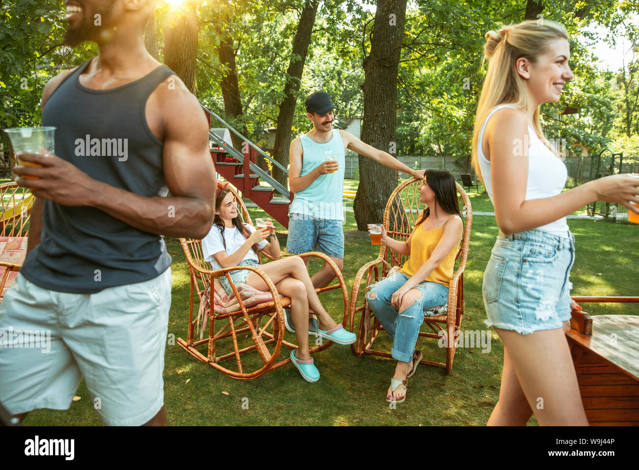 Group of happy friends having beer and barbecue party at sunny day ...